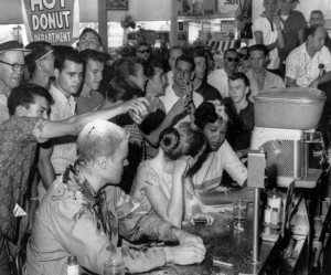FILE - In this May 28, 1963 file photo, a group of whites pour sugar, ketchup and mustard over the heads of Tougaloo College student demonstrators at a sit-in demonstration at a Woolworth's lunch counter in Jackson, Miss. Seated at the counter, from left, are Tougaloo College professor John Salter,and students Joan Trumpauer and Anne Moody. John Salter, who also used the name John Hunter Gray, died Monday, Jan. 7, 2019 at his home in Pocatello, Idaho.  Relatives say he was 84 when he died Monday after an illness. (Fred Blackwell/The Clarion-Ledger via AP, File) ORG XMIT: MSJAD701